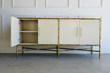 Load image into Gallery viewer, Palm Beach–inspired Ambella Home cabinet with faux bamboo frame and satin brass pulls, shown with doors open to display generous interior storage.