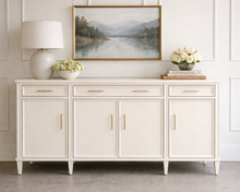 Load image into Gallery viewer, Avalaire Sideboard in White Dove styled with artwork and a table lamp, highlighting the collection’s clean lines and versatile storage design by Good Bones Furniture.