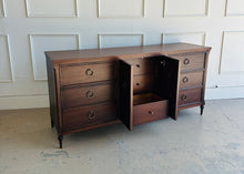 Load image into Gallery viewer, Boylan 9 drawer credenza dresser in dark walnut with crotch mahogany veneer, shown with center cabinet and drawer open by Good Bones Furniture.