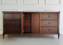 Load image into Gallery viewer, Front view of the Boylan 9 drawer credenza dresser featuring mahogany construction and patina brass ring hardware, with center cabinet door open.