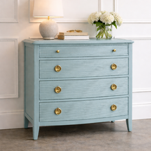 Load image into Gallery viewer, Camille Chest in French Blue, a four-drawer chest with subtle linear drawer detailing and brass hardware, styled in a bedroom setting for compact storage and accent furniture use.