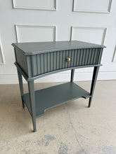 Load image into Gallery viewer, Bring timeless craftsmanship and subtle sophistication to your space with the Taylor Side Table. Crafted from solid mango wood, this versatile piece features a beautifully fluted single drawer front with a false key lock, gracefully curved apron, and elegant tapered legs. An open lower shelf adds both visual balance and extra storage or styling potential. Good Bones Furniture