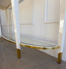 Load image into Gallery viewer, Close-up view of the Judith Leiber console legs and feet, showing the white lacquered structure with polished brass caps and curved lower stretcher