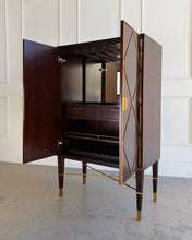 Load image into Gallery viewer, Angled left front view of the Theodore Alexander Max bar cabinet with both doors open, revealing an illuminated mirrored interior, stemware hangers, wine storage, and interior drawers.