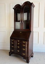 Load image into Gallery viewer, Vintage Hooker Secretary closed view featuring double-arched crown, glass-paneled display cabinet, drop-front desk, and warm mahogany tone.