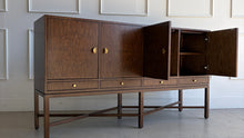 Load image into Gallery viewer, Side angle of Basil Sideboard with cabinet doors open showing interior shelving and refined walnut burl casework on elevated X-stretcher base.
