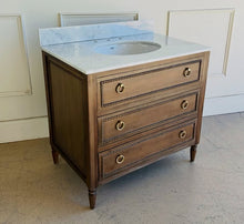 Load image into Gallery viewer, Upgrade your space with this stunning Bramble Cholet single bathroom vanity, where classic design meets modern functionality. Crafted from solid mahogany in a variety of finishes, this piece brings warmth and timeless beauty to any bathroom.
Topped with luxurious marble, with a white American Standard undermount sink. Good Bones Furniture
