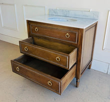 Load image into Gallery viewer, Upgrade your space with this stunning Bramble Cholet single bathroom vanity, where classic design meets modern functionality. Crafted from solid mahogany in a variety of finishes, this piece brings warmth and timeless beauty to any bathroom.
Topped with luxurious marble, with a white American Standard undermount sink. Good Bones Furniture
