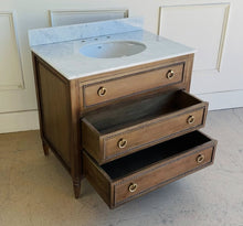 Load image into Gallery viewer, Upgrade your space with this stunning Bramble Cholet single bathroom vanity, where classic design meets modern functionality. Crafted from solid mahogany in a variety of finishes, this piece brings warmth and timeless beauty to any bathroom.
Topped with luxurious marble, with a white American Standard undermount sink. Good Bones Furniture
