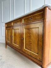 Load image into Gallery viewer,  A study in balance and material, the Riley Sideboard draws from European neoclassical design—most notably Louis XVI—reimagined through a quieter, more modern lens. The form is clean and architectural, defined by symmetry, framed panels, and gently tapered legs that give the piece a sense of structure without excess. Cerejeira veneers are carefully bookmatched across each door, revealing a striking cathedral grain that brings movement and depth to the façade. Good Bones Furniture
