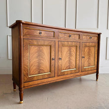 Load image into Gallery viewer,  A study in balance and material, the Riley Sideboard draws from European neoclassical design—most notably Louis XVI—reimagined through a quieter, more modern lens. The form is clean and architectural, defined by symmetry, framed panels, and gently tapered legs that give the piece a sense of structure without excess. Cerejeira veneers are carefully bookmatched across each door, revealing a striking cathedral grain that brings movement and depth to the façade. Good Bones Furniture
