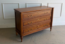 Load image into Gallery viewer, Gently used Ciborium chest by Sarreid showcases timeless European-inspired styling and exceptional craftsmanship. Constructed of solid walnut with a warm fruitwood finish, the piece features fluted corner columns, tapered turned legs, and three generously sized drawers accented with classic brass pulls and decorative faux keyhole escutcheons. Good Bones Furniture
