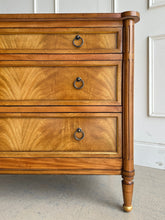 Load image into Gallery viewer, Elegant and effortlessly functional, the Riley Mahogany Chest pairs classic proportions with luxe details. A cerejeira (Brazilian oak) veneer creates a striking feathered grain across the drawer fronts, framed by subtle gold trim that’s echoed on the turned feet. Finished in a warm mahogany tone with mahogany or marble top and fitted with antique brass ring pulls, Riley brings tailored sophistication to bedrooms, entryways, or living spaces while offering generous, everyday storage. Good Bones Furniture
