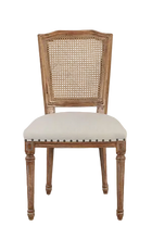 Load image into Gallery viewer, The Ellen Side Chair combines timeless European-inspired detailing with everyday durability. Crafted from solid mango wood, its distressed Beachwood finish highlights the carved frame, turned legs, and warm natural character of the wood. A handwoven cane back adds airy texture, while the upholstered seat is finished with classic nailhead trim. Sand Revolution Performance Fabric. Good Bones Furniture
