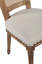 Load image into Gallery viewer, The Ellen Side Chair combines timeless European-inspired detailing with everyday durability. Crafted from solid mango wood, its distressed Beachwood finish highlights the carved frame, turned legs, and warm natural character of the wood. A handwoven cane back adds airy texture, while the upholstered seat is finished with classic nailhead trim. Sand Revolution Performance Fabric. Good Bones Furniture
