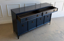 Load image into Gallery viewer, This like-new Hekman sideboard has been professionally refinished in a custom dark Sherwin Williams Naval lacquer, creating a rich, sophisticated finish that highlights the cabinet's clean lines and subtle oak grain texture. Antiqued brass hardware and a matching brass base add warmth and contrast, giving the piece a tailored, designer-inspired look. Good Bones Furniture

