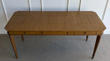 Load image into Gallery viewer, This Hickory White Home Office Desk is an open-box showroom sample with clean lines, tailored proportions, and a warm wood finish that brings a refined, classic presence to a workspace. The long rectangular top offers generous room for a laptop, writing materials, and everyday office essentials, while the slender fluted legs keep the silhouette light and elegant. Good Bones Furniture
