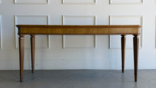 Load image into Gallery viewer, This Hickory White Home Office Desk is an open-box showroom sample with clean lines, tailored proportions, and a warm wood finish that brings a refined, classic presence to a workspace. The long rectangular top offers generous room for a laptop, writing materials, and everyday office essentials, while the slender fluted legs keep the silhouette light and elegant. Good Bones Furniture
