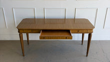 Load image into Gallery viewer, This Hickory White Home Office Desk is an open-box showroom sample with clean lines, tailored proportions, and a warm wood finish that brings a refined, classic presence to a workspace. The long rectangular top offers generous room for a laptop, writing materials, and everyday office essentials, while the slender fluted legs keep the silhouette light and elegant. Good Bones Furniture
