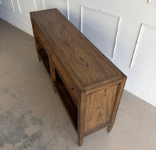 Load image into Gallery viewer, The Hickory White Tulia Console combines tailored craftsmanship with warm natural character. Finished in the rich Autumn finish, the wood grain is beautifully highlighted across the top and case, giving the piece a relaxed but refined presence. The design features two fluted-front drawers with small brass knobs, paired with open shelving below for additional storage or display. Good Bones Furniture
