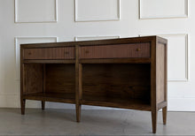 Load image into Gallery viewer, The Hickory White Tulia Console combines tailored craftsmanship with warm natural character. Finished in the rich Autumn finish, the wood grain is beautifully highlighted across the top and case, giving the piece a relaxed but refined presence. The design features two fluted-front drawers with small brass knobs, paired with open shelving below for additional storage or display. Good Bones Furniture
