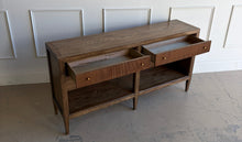 Load image into Gallery viewer, The Hickory White Tulia Console combines tailored craftsmanship with warm natural character. Finished in the rich Autumn finish, the wood grain is beautifully highlighted across the top and case, giving the piece a relaxed but refined presence. The design features two fluted-front drawers with small brass knobs, paired with open shelving below for additional storage or display. Good Bones Furniture
