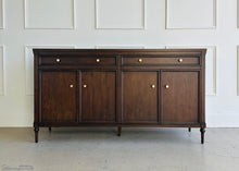 Load image into Gallery viewer, Dark wooden sideboard against a white paneled wall
