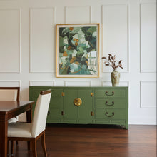 Load image into Gallery viewer, Green dresser with gold accents against a white paneled wall
