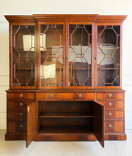 Load image into Gallery viewer, The Jonathan Charles Mahogany Breakfront Secretary Bookcase is a statement piece that combines the functionality of a library cabinet, secretary desk, display cabinet, and storage credenza in a single heirloom-quality design. Crafted with richly figured flame mahogany veneers, the cabinet showcases the level of craftsmanship that has made Jonathan Charles a respected name among collectors, designers, and luxury furniture retailers. Good Bones Furniture
