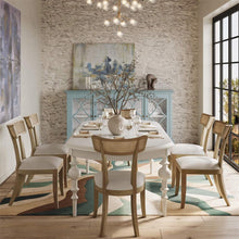 Load image into Gallery viewer, Kraton butterfly oval extension dining table shown extended and styled in a dining room, seating guests comfortably with self-storing leaf, solid mahogany table by Good Bones Furniture

