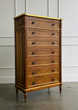 Load image into Gallery viewer, This stately Louis XVI–style chest combines generous storage with a tall, space-conscious silhouette. Crafted from mahogany solids with richly figured cerejeira veneers, it features seven spacious drawers framed by hand-applied gold accents. Fluted corner columns, paneled sides, decorative metal knobs, and tapered legs. Good Bones Furniture
