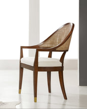 Load image into Gallery viewer, The Modern History Lyon Chair blends refined craftsmanship with classic European-inspired design. Its sculptural frame features graceful curves and a woven cane back that creates a light, elegant silhouette while adding natural texture. A generously upholstered seat provides comfort for extended dining or occasional seating. Brass boot details at the feet add a tailored accent while protecting the legs. Good Bones Furniture
