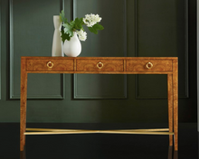 Load image into Gallery viewer, Elevate your entryway or living space with the Modernist Three Drawer Hall Console, where form and function come together in perfect harmony. Crafted from exquisite Ashe Burl Veneer, this console highlights nature’s artistry through its intricate grain patterns and subtle tonal variations, ensuring each piece is truly one-of-a-kind. The warm elegance of the wood is further enhanced by polished brass hardware, adding a refined, modern touch that complements the console’s clean lines.
