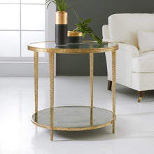 Load image into Gallery viewer, The Modern History Sculpture Round Table pairs bold texture with clean modern lines. Crafted with a richly textured antique brass finish, the circular frame has a sculptural presence that adds warmth and visual depth to a living space. A clear glass top keeps the design light and airy while showcasing the distinctive hammered brass detailing. Good Bones Furniture
