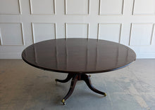 Load image into Gallery viewer, Designed by Mr. &amp; Mrs. Howard for Sherrill Furniture, this elegant 72" round dining table combines timeless Georgian-inspired styling with exceptional craftsmanship. The rich mahogany finish highlights the beautiful veneer pattern, while the graceful four-splay pedestal base is accented with brass toe caps and casters. Good Bones Furniture
