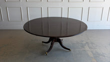 Load image into Gallery viewer, Designed by Mr. &amp; Mrs. Howard for Sherrill Furniture, this elegant 72" round dining table combines timeless Georgian-inspired styling with exceptional craftsmanship. The rich mahogany finish highlights the beautiful veneer pattern, while the graceful four-splay pedestal base is accented with brass toe caps and casters. Good Bones Furniture
