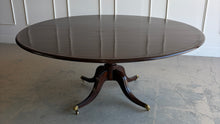 Load image into Gallery viewer, Designed by Mr. &amp; Mrs. Howard for Sherrill Furniture, this elegant 72" round dining table combines timeless Georgian-inspired styling with exceptional craftsmanship. The rich mahogany finish highlights the beautiful veneer pattern, while the graceful four-splay pedestal base is accented with brass toe caps and casters. Good Bones Furniture
