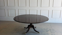 Load image into Gallery viewer, Designed by Mr. &amp; Mrs. Howard for Sherrill Furniture, this elegant 72" round dining table combines timeless Georgian-inspired styling with exceptional craftsmanship. The rich mahogany finish highlights the beautiful veneer pattern, while the graceful four-splay pedestal base is accented with brass toe caps and casters. Good Bones Furniture
