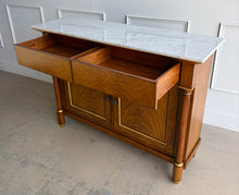 Load image into Gallery viewer, The Philippe Sideboard brings French Empire-inspired elegance and storage to a dining room, entryway, or living space. Crafted with richly figured cerejeira veneer, it features bookmatched door and drawer fronts, fluted columns, and hand-applied gold highlights. A polished white marble top creates a striking contrast with the warm wood tones. Two spacious drawers and a double-door cabinet with an interior shelf provide ample storage for serving pieces, linens, and other essentials. Good Bones Furniture
