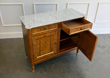 Load image into Gallery viewer, The Riley 2 Door Sideboard brings the graceful symmetry of European neoclassical design to a versatile, more compact scale. Crafted from mahogany solids with beautifully bookmatched cerejeira veneers, each door showcases a dramatic cathedral grain framed by hand-painted gold detailing. Two drawers keep smaller essentials close at hand, while the cabinet below provides generous concealed storage. Good Bones Furniture
