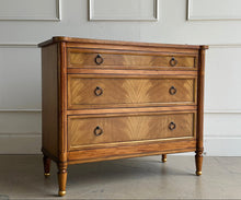 Load image into Gallery viewer, Elegant and effortlessly functional, the Riley Mahogany Chest pairs classic proportions with luxe details. A cerejeira (Brazilian oak) veneer creates a striking feathered grain across the drawer fronts, framed by subtle gold trim that’s echoed on the turned feet. Finished in a warm mahogany tone with mahogany or marble top and fitted with antique brass ring pulls, Riley brings tailored sophistication to bedrooms, entryways, or living spaces while offering generous, everyday storage. Good Bones Furniture
