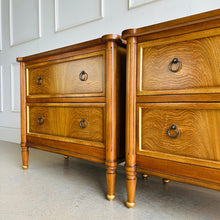 Load image into Gallery viewer, Elevate your bedside with the Riley Nightstand, a refined two-drawer piece that pairs timeless form with modern function. The front is clad in striking cerejeira veneer arranged in a radiant pattern and framed with hand-applied gold trim, while tapered legs finish with gilded caps for a subtle luxe note. Thoughtful scaling, warm mahogany tones, and elegant antique brass ring pulls make Riley an easy fit for both classic and contemporary bedrooms. Good Bones Furniture
