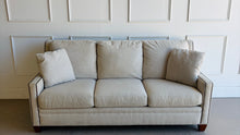 Load image into Gallery viewer, Crafted by renowned North Carolina manufacturer Sherrill Furniture, this custom upholstered sofa offers the exceptional comfort, craftsmanship, and timeless styling that have made the brand a favorite among designers and luxury furniture buyers. Upholstered in a versatile neutral fabric, the sofa features clean transitional track arms, elegant double-row nailhead trim, loose back cushions, and exposed tapered wood feet. Good Bones Furniture
