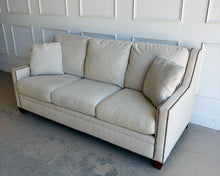 Load image into Gallery viewer, Crafted by renowned North Carolina manufacturer Sherrill Furniture, this custom upholstered sofa offers the exceptional comfort, craftsmanship, and timeless styling that have made the brand a favorite among designers and luxury furniture buyers. Upholstered in a versatile neutral fabric, the sofa features clean transitional track arms, elegant double-row nailhead trim, loose back cushions, and exposed tapered wood feet. Good Bones Furniture
