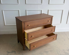 Load image into Gallery viewer, The Sherrill Occasional 3 Drawer Single Dresser offers clean transitional styling with refined materials and balanced proportions. Crafted from maple solids and quartered walnut veneers, this piece showcases subtle linear grain movement enhanced by the warm Cashew finish. Good Bones Furniture
