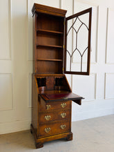 Load image into Gallery viewer, Classic English craftsmanship never goes out of style. This Southampton George III Style Secretary Bookcase is a beautifully proportioned piece that combines elegant display storage, a functional writing desk, and generous drawer storage within a refined, space-saving silhouette. Rich walnut and burl walnut veneers showcase striking natural grain throughout, while the leaded glass door, dentil crown molding, and original Chippendale-style brass hardware add timeless architectural character. Good Bones 
