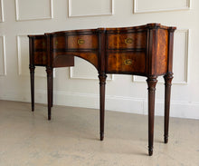 Load image into Gallery viewer, Angled left view of the Theodore Alexander Stanhope Row Sideboard emphasizing its serpentine façade, concave drawer fronts, turned legs, and classic proportions, photographed at Good Bones Furniture in Raleigh, NC.
