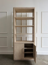 Load image into Gallery viewer, The Horizon Etagere by Theodore Alexander combines generous display space with a light, contemporary silhouette. Crafted from oak in a pale Day finish, its softly rounded frame and finely reeded details introduce texture while preserving the collection’s clean lines. Multiple open shelves provide ample room for books, art, and collected objects, while the two-door cabinet below offers convenient concealed storage. Good Bones Furniture

