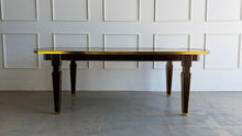 Load image into Gallery viewer, Theodore Alexander Sebastiano Dining Table pairs a historic silhouette with a modern, tailored edge. Its gently curved rectangular top is framed by a brass-bound apron that gives the piece a crisp, architectural presence, while slatted baluster legs outlined in gilt add depth and refinement. Open box showroom sample. Good Bones Furniture
