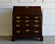Load image into Gallery viewer, This traditional Chippendale mahogany secretary combines classic American craftsmanship with everyday functionality in a compact footprint. Crafted in rich mahogany with a warm satin finish, it features a slant-front writing surface that opens to reveal a thoughtfully organized interior complete with pigeonholes, two small drawers, and a center cabinet for storing stationery and essentials. Good Bones Furniture
